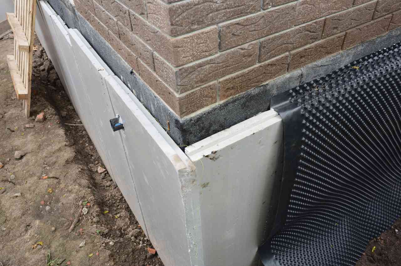 Foundation insulation with damp proofing applied to corner for moisture protection.